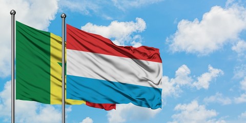 Senegal and Luxembourg flag waving in the wind against white cloudy blue sky together. Diplomacy concept, international relations.