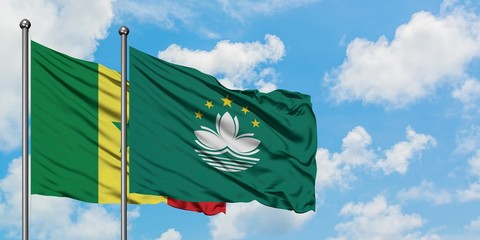 Senegal and Macao flag waving in the wind against white cloudy blue sky together. Diplomacy concept, international relations.