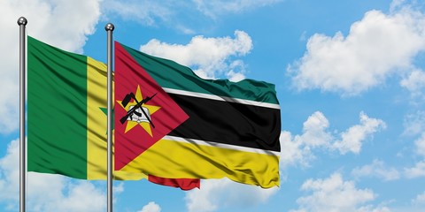 Senegal and Mozambique flag waving in the wind against white cloudy blue sky together. Diplomacy concept, international relations.