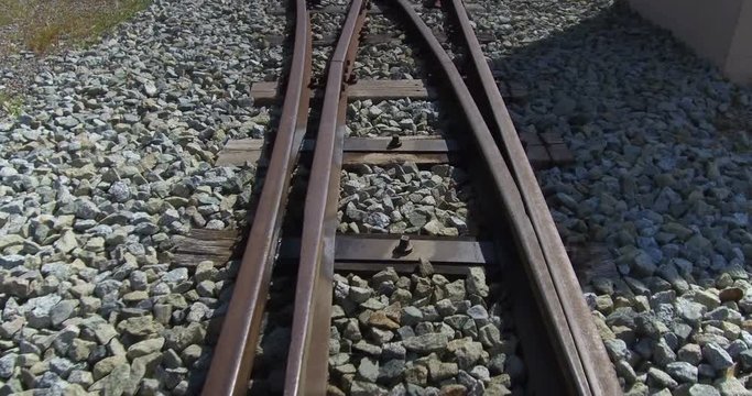 Subjective vision in motion over old train tracks. Narrow track, with old railroad switch and bifurcation of tracks.