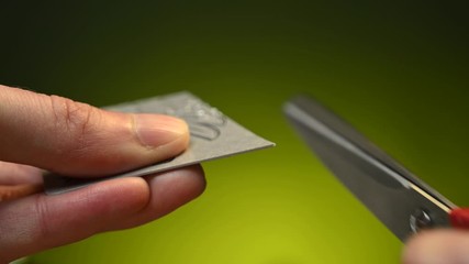 man cuts a bank card in half