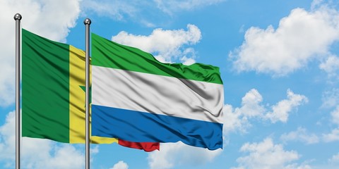 Senegal and Sierra Leone flag waving in the wind against white cloudy blue sky together. Diplomacy concept, international relations.
