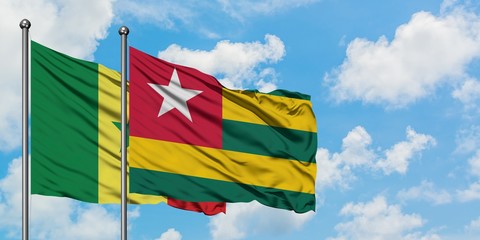 Senegal and Togo flag waving in the wind against white cloudy blue sky together. Diplomacy concept, international relations.