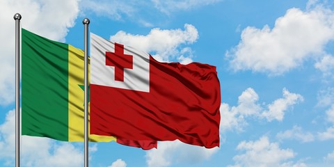 Senegal and Tonga flag waving in the wind against white cloudy blue sky together. Diplomacy concept, international relations.