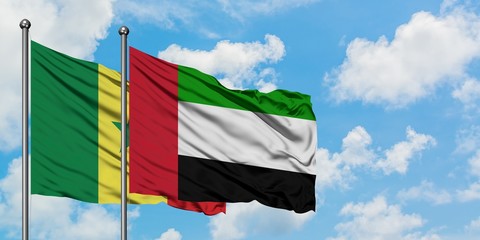 Senegal and United Arab Emirates flag waving in the wind against white cloudy blue sky together. Diplomacy concept, international relations.