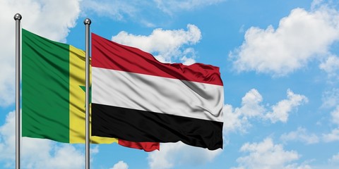 Senegal and Yemen flag waving in the wind against white cloudy blue sky together. Diplomacy concept, international relations.