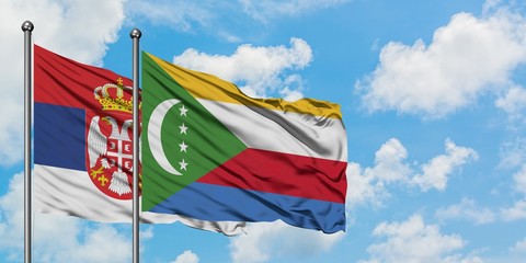 Serbia and Comoros flag waving in the wind against white cloudy blue sky together. Diplomacy concept, international relations.