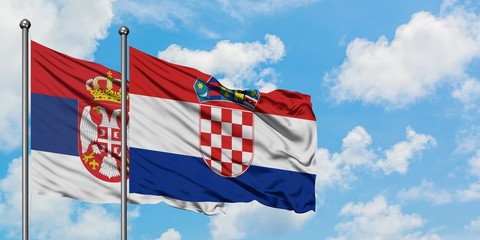 Serbia and Croatia flag waving in the wind against white cloudy blue sky together. Diplomacy concept, international relations.