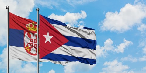 Serbia and Cuba flag waving in the wind against white cloudy blue sky together. Diplomacy concept, international relations.