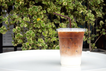 Glass of ice latte in plastic cup. Easy pagage of most useful. Favorite menu for caffeine lover with milk.