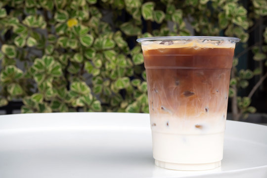 Glass of ice latte in plastic cup. Easy pagage of most useful. Favorite menu for caffeine lover with milk.