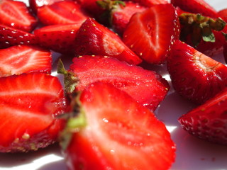 Background of sliced strawberries in a white plate closeup