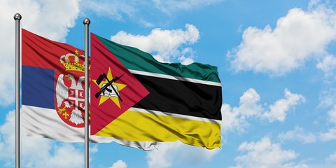 Serbia and Mozambique flag waving in the wind against white cloudy blue sky together. Diplomacy concept, international relations.