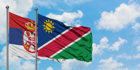 Serbia and Namibia flag waving in the wind against white cloudy blue sky together. Diplomacy concept, international relations.
