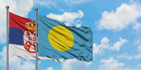 Serbia and Palau flag waving in the wind against white cloudy blue sky together. Diplomacy concept, international relations.