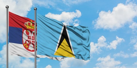 Serbia and Saint Lucia flag waving in the wind against white cloudy blue sky together. Diplomacy concept, international relations.