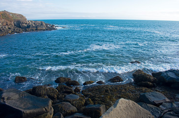Fototapeta na wymiar Small waves crashing into rocky shoreline viewed from Cape Neddick, York, Maine, USA. -04