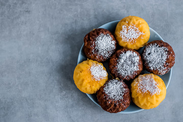 Useful buckwheat, rice and corn muffins with lemon and chocolate on a blue plate.
