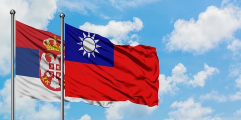 Serbia and Taiwan flag waving in the wind against white cloudy blue sky together. Diplomacy concept, international relations.