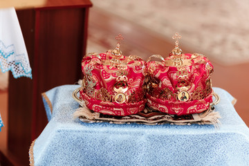 Wedding crowns. Wedding crown in church ready for marriage ceremony. Golden crowns and cross laying on a church table ready for a wedding ceremony