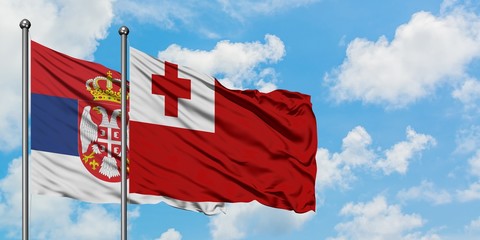 Serbia and Tonga flag waving in the wind against white cloudy blue sky together. Diplomacy concept, international relations.