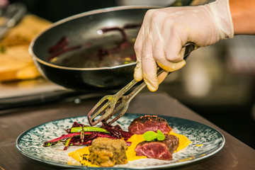 Close up hands of chef preparing food in the kitchen of a restaurant, cooking concept