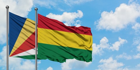 Seychelles and Bolivia flag waving in the wind against white cloudy blue sky together. Diplomacy concept, international relations.