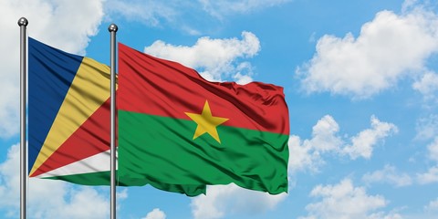 Seychelles and Burkina Faso flag waving in the wind against white cloudy blue sky together. Diplomacy concept, international relations.