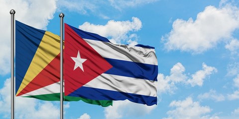 Seychelles and Cuba flag waving in the wind against white cloudy blue sky together. Diplomacy concept, international relations.