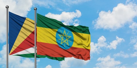 Seychelles and Ethiopia flag waving in the wind against white cloudy blue sky together. Diplomacy concept, international relations.