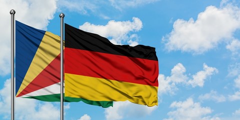 Seychelles and Germany flag waving in the wind against white cloudy blue sky together. Diplomacy concept, international relations.