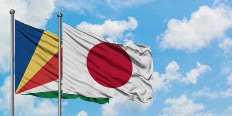 Seychelles and Japan flag waving in the wind against white cloudy blue sky together. Diplomacy concept, international relations.