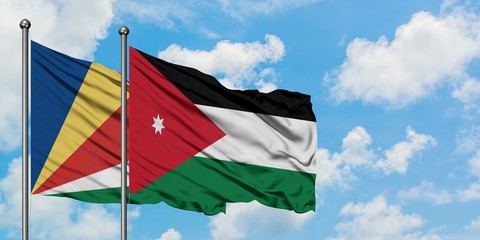 Seychelles and Jordan flag waving in the wind against white cloudy blue sky together. Diplomacy concept, international relations.