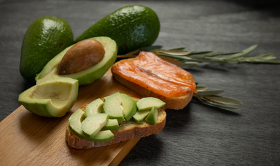 Salmon on bread slices gourmet appetizer with avocado. Fresh salmon   and avocado sandwich. Healthy food concept. Breakfast with avocado and salmon.