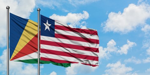 Seychelles and Liberia flag waving in the wind against white cloudy blue sky together. Diplomacy concept, international relations.