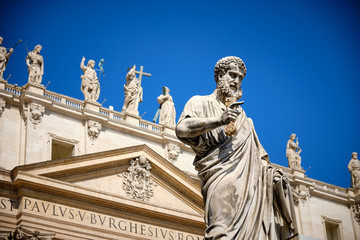 Statue of Saint Peter and Saint Peter's Basilica at background in St. Peter's Square, Vatican City, Rome, Italy