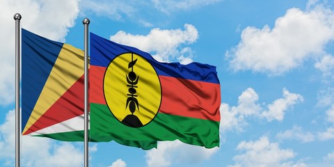 Seychelles and New Caledonia flag waving in the wind against white cloudy blue sky together. Diplomacy concept, international relations.
