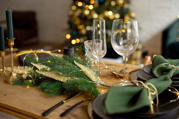 Table served for Christmas dinner in living room, close-up view, table setting, Christmas decoration.