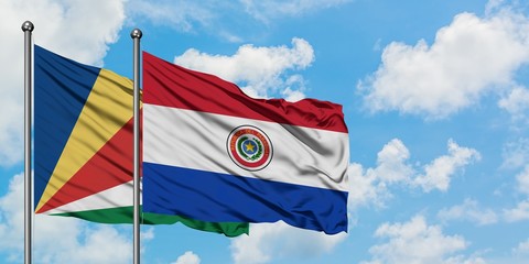 Seychelles and Paraguay flag waving in the wind against white cloudy blue sky together. Diplomacy concept, international relations.