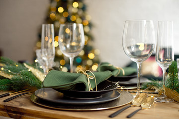 Table served for Christmas dinner in living room, close-up view, table setting, Christmas decoration.