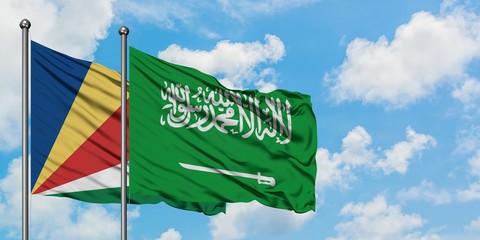 Seychelles and Saudi Arabia flag waving in the wind against white cloudy blue sky together. Diplomacy concept, international relations.