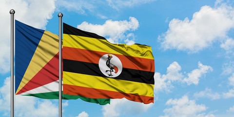 Seychelles and Uganda flag waving in the wind against white cloudy blue sky together. Diplomacy concept, international relations.