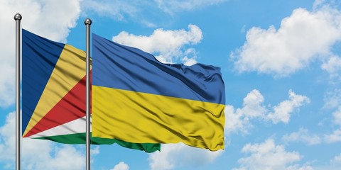 Seychelles and Ukraine flag waving in the wind against white cloudy blue sky together. Diplomacy concept, international relations.