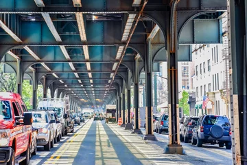 Plexiglas foto achterwand Onderaanzicht van verhoogde treinbaan nyc. Verkeer te wachten in de weg in een zonnige dag. Reizen en verkeer concepten. Bronx, NYC, VS © dhvstockphoto