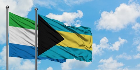 Sierra Leone and Bahamas flag waving in the wind against white cloudy blue sky together. Diplomacy concept, international relations.