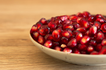 Pomegranate seeds on a plate background