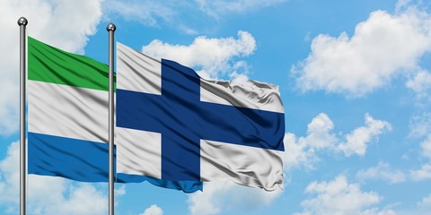 Sierra Leone and Finland flag waving in the wind against white cloudy blue sky together. Diplomacy...
