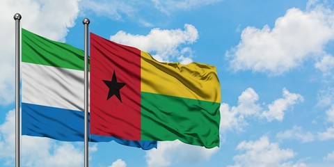 Sierra Leone and Guinea Bissau flag waving in the wind against white cloudy blue sky together. Diplomacy concept, international relations.