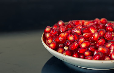 Pomegranate seeds on a plate background