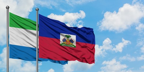 Sierra Leone and Haiti flag waving in the wind against white cloudy blue sky together. Diplomacy...
